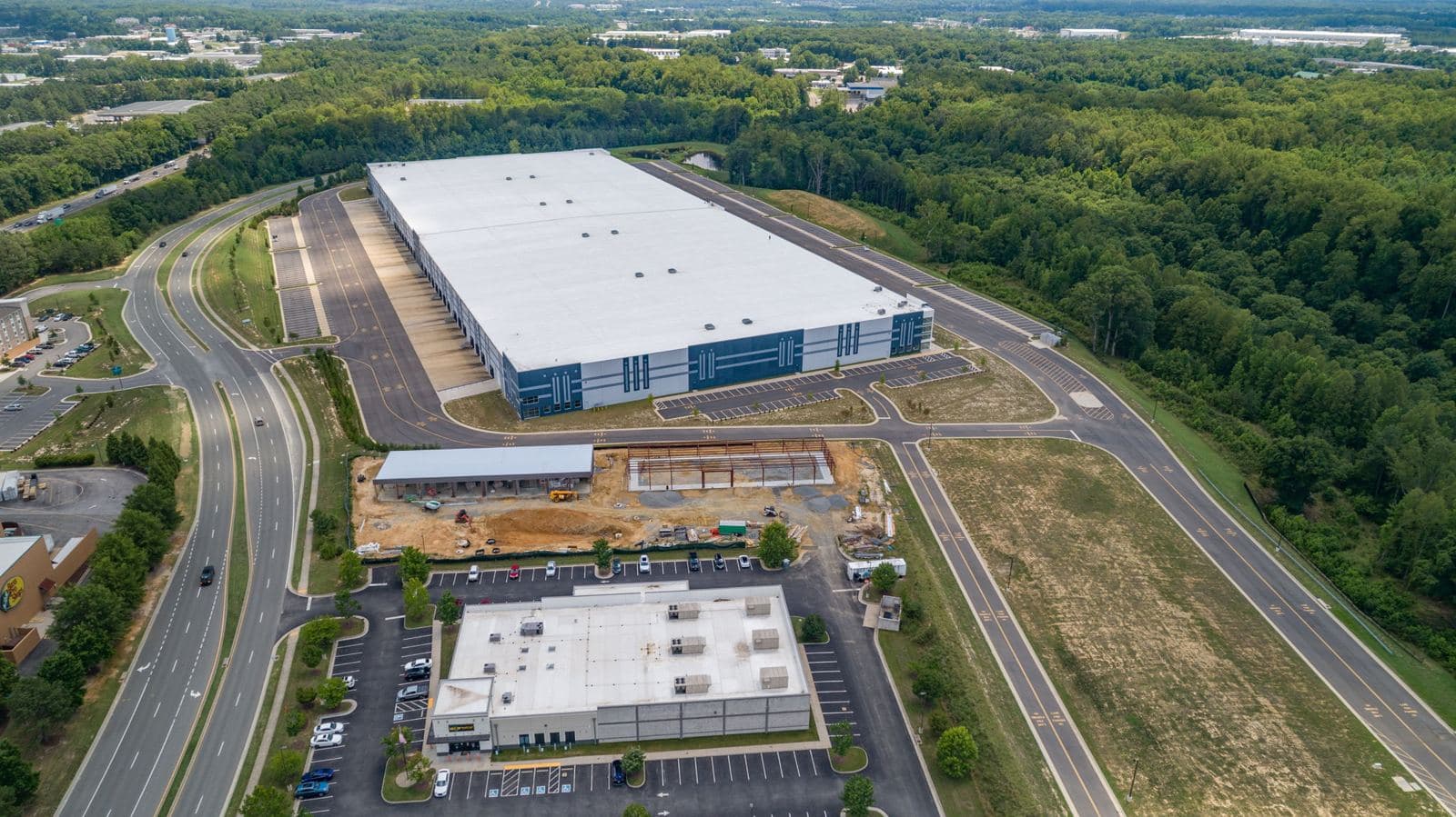 Aerial of the Lewistown site with I-95 traffic beyond and a major distribution center behind it