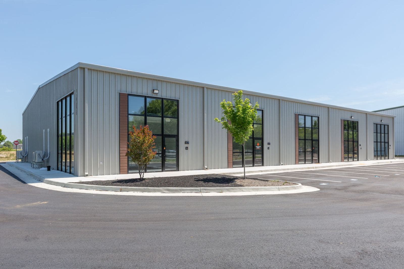 Corner view of the finished Shannon Park building with landscaping and new parking